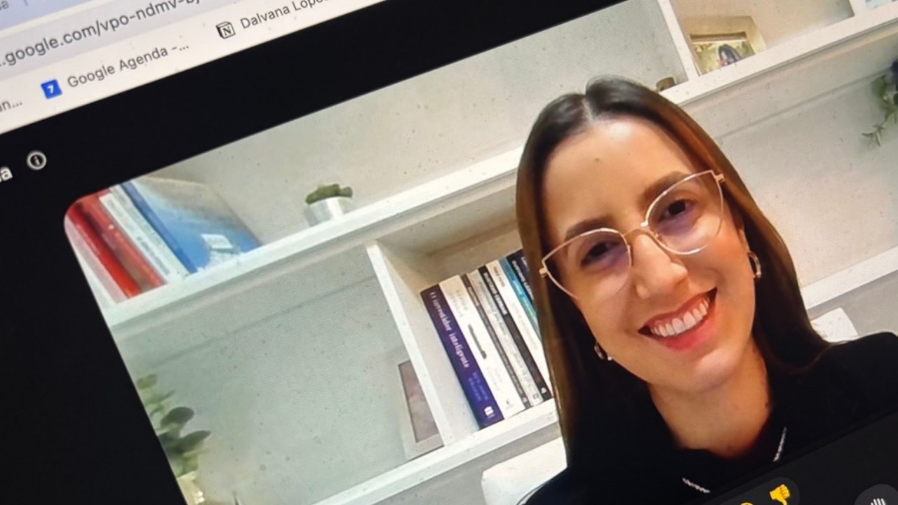 Aluna do Conversation Club sorrindo durante a aula em videochamada